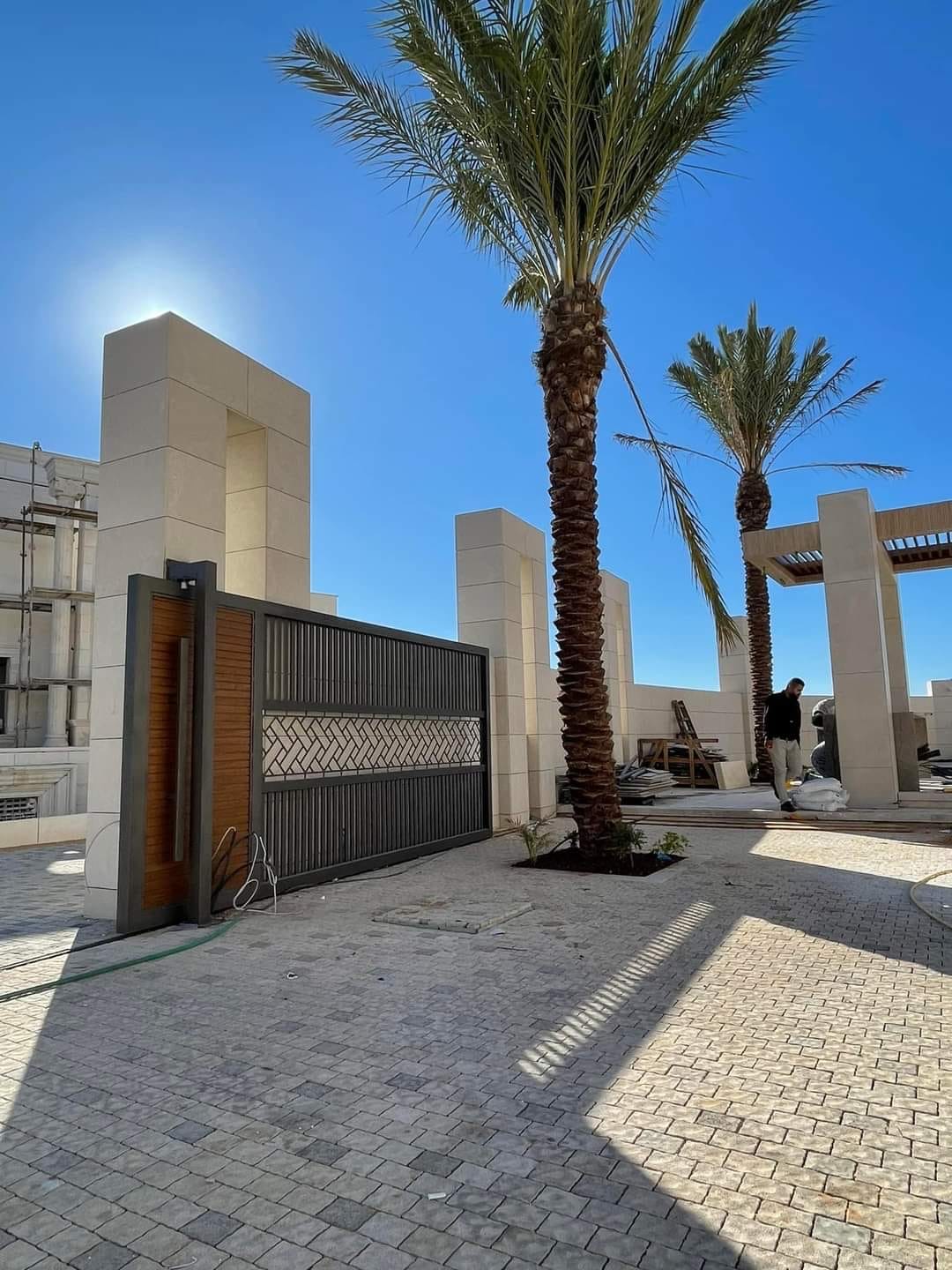 بوابة ومدخل خارجي بتفاصيل حجرية ونخيل